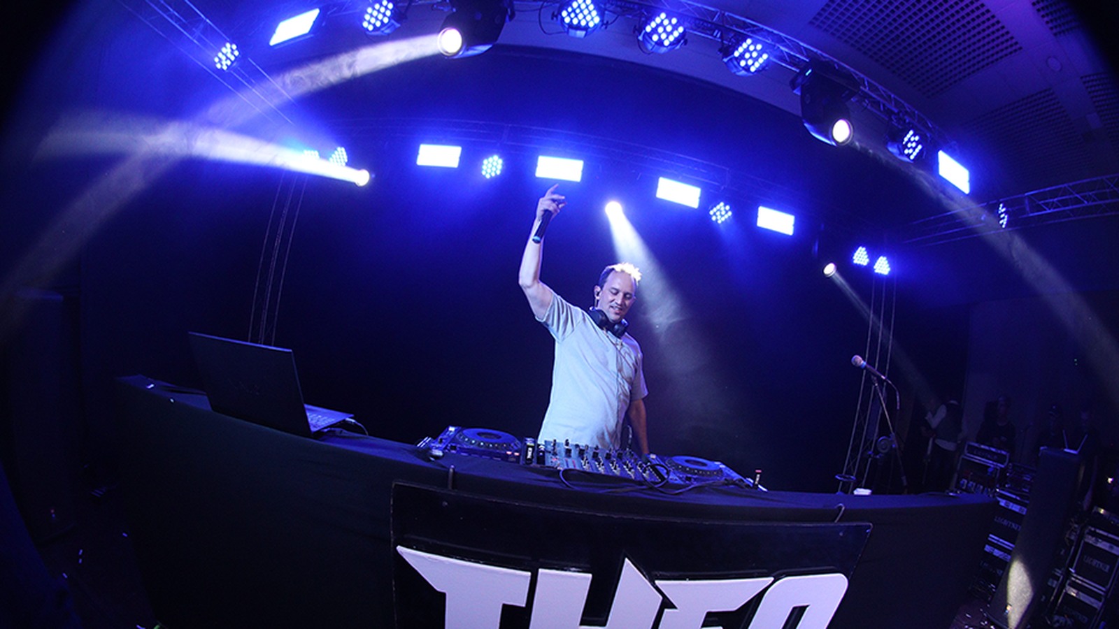 DJ Theo na cabine, sob iluminação azul