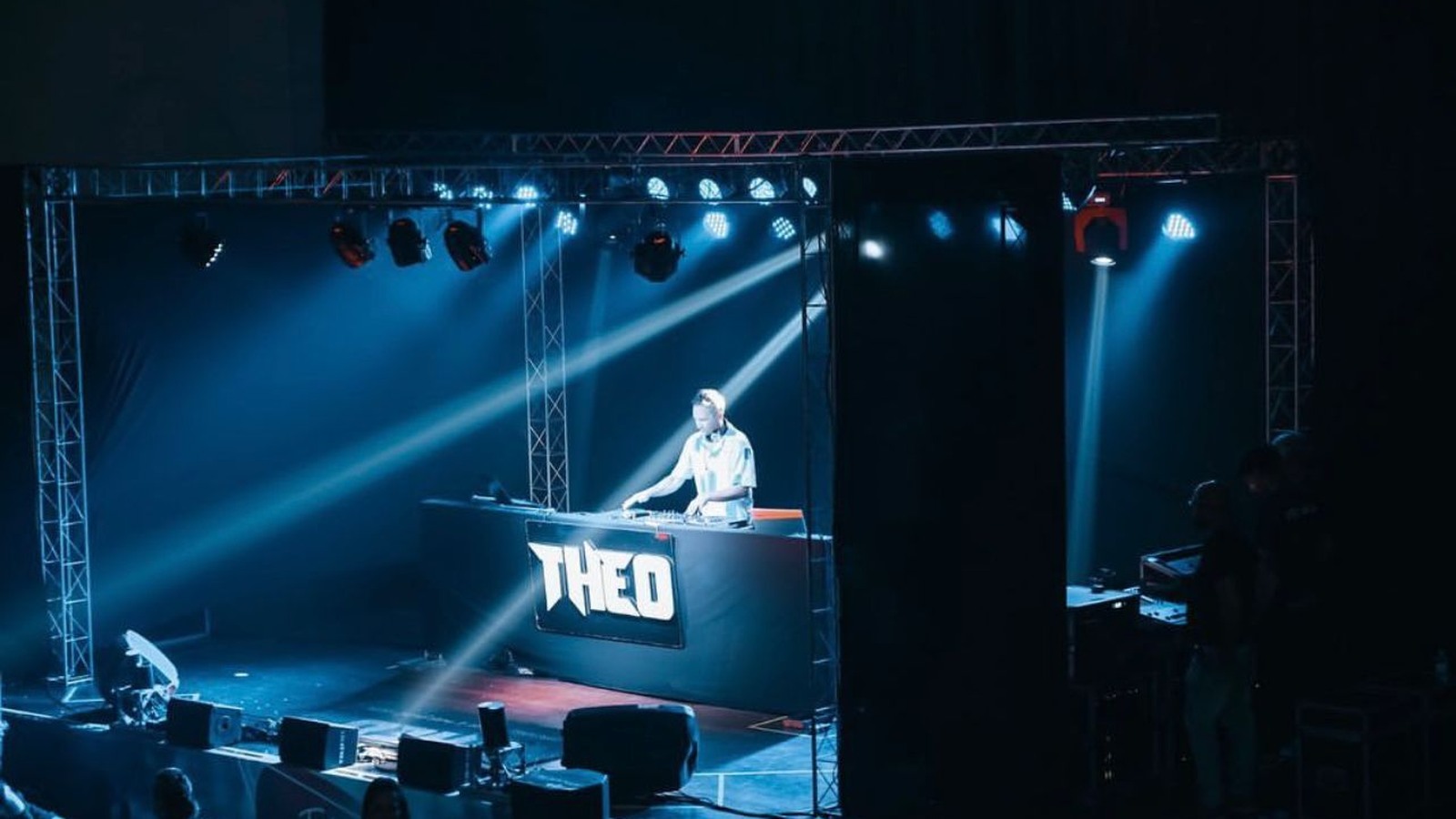 DJ Theo em palco com efeitos de luz