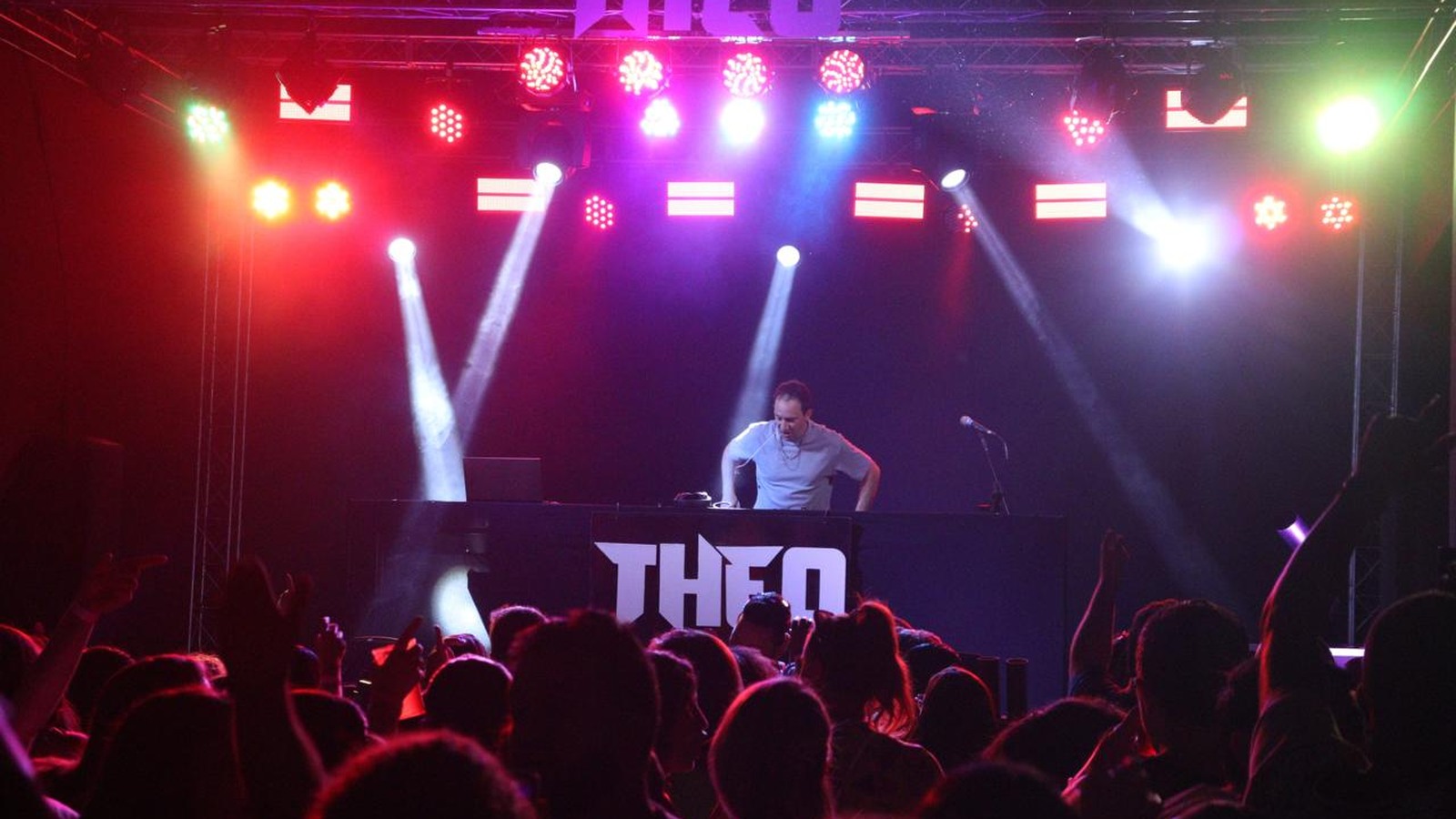 DJ Theo em show com iluminação colorida