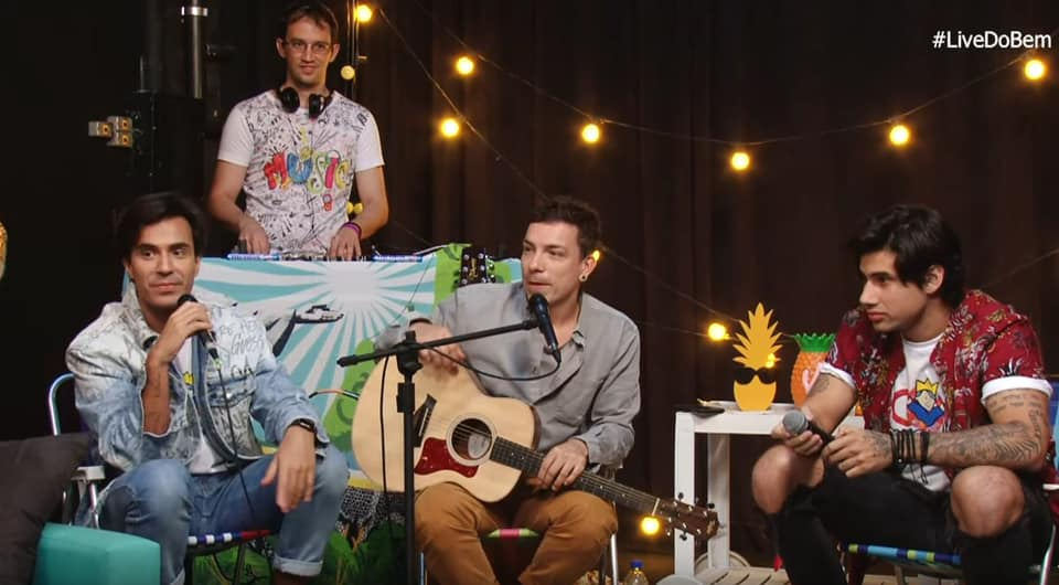 DJ Theo atrás da cabine durante a Live do Bem, com os apresentadores e convidados